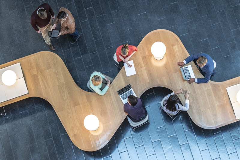 aerial photo of colleagues at squiggle shaped desk