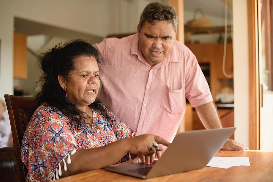 A couple looking at something on their laptop at home