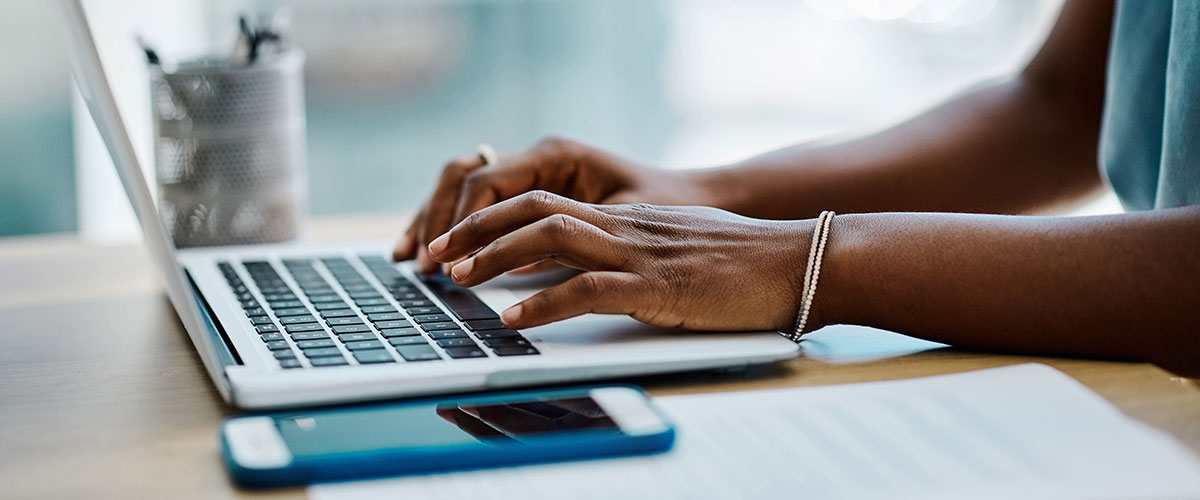 Close up image of hands on a laptop keyboard