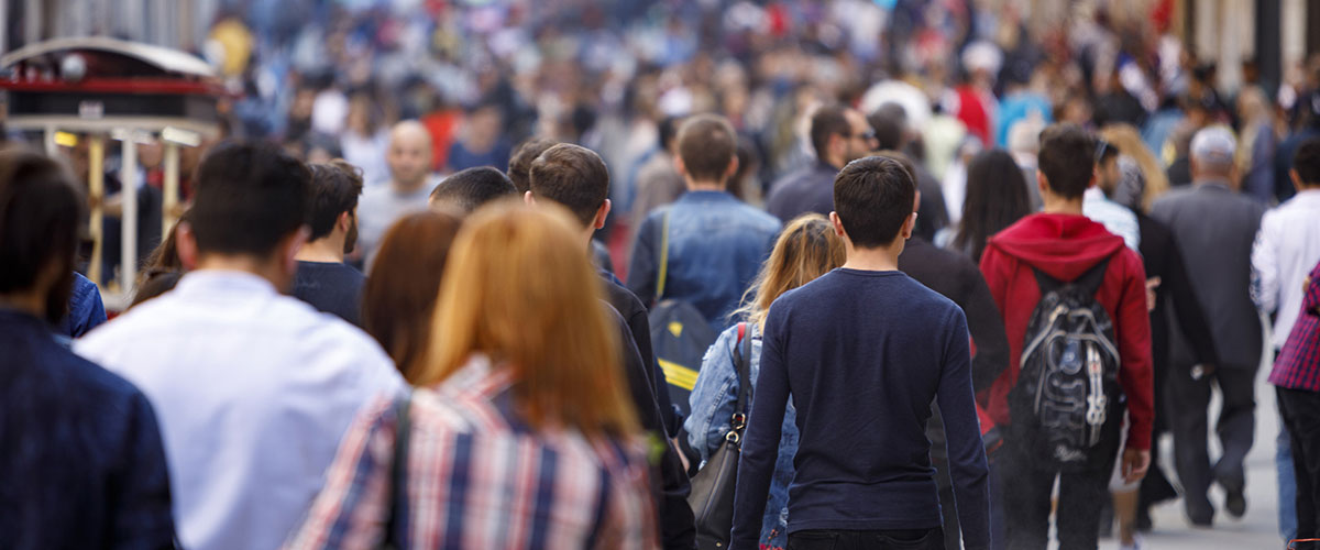 Hundreds of people walking in one directionthrough a city envrionment 