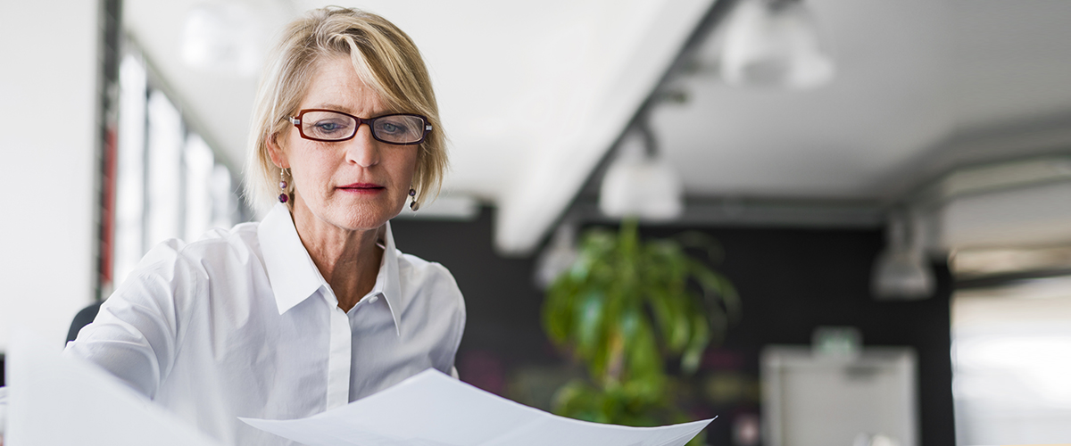 Businesswoman examining documents at desk