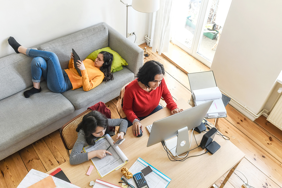Bird's eye view of family in lounge room using devices